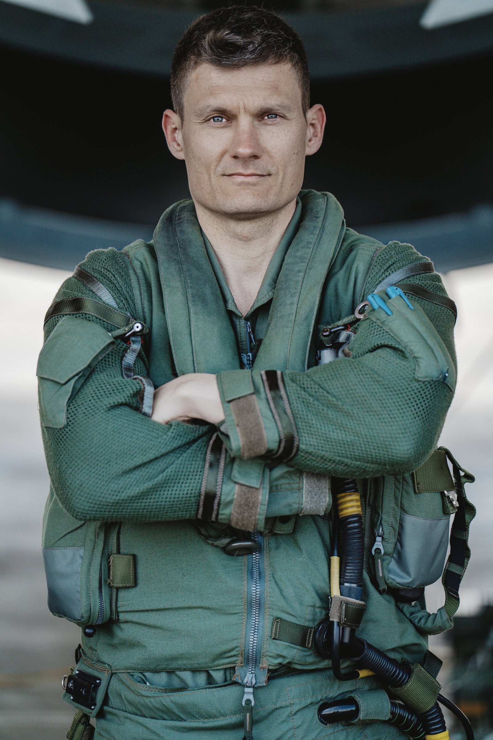 Michael Schaudienst in Fliegerkombi vor einem Eurofighter, die Arme verschränkt